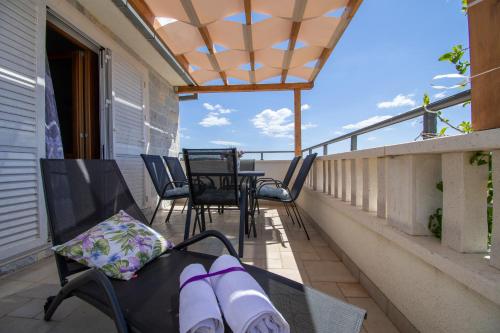 a porch with chairs and tables on a balcony at Apartmani Selo Luka in Ražanj