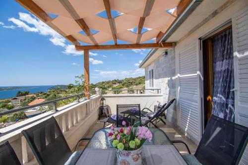 a balcony with a table and flowers on it at Apartmani Selo Luka in Ražanj