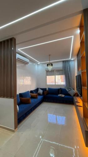 a living room with a blue couch and a tv at Exclusive Modern Garden Flat ,Marrakech in Marrakesh
