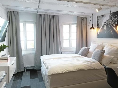 a bedroom with a large white bed and windows at NOX HOTEL - Digital-Check-In - No Reception - nahe Bretten & Karlsruhe - 5 Future in Wössingen
