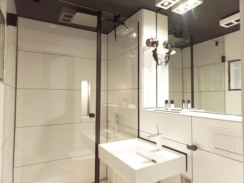 a white bathroom with a sink and a shower at NOX HOTEL - Digital-Check-In - No Reception - nahe Bretten & Karlsruhe - 5 Future in Wössingen