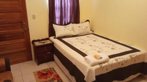 a small bedroom with a bed with a window at DadaG's Guest House in Punta Gorda