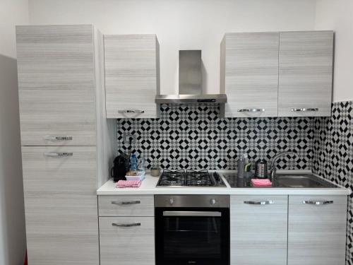 a kitchen with white cabinets and a stove top oven at EDEL Vacation Home in Terni