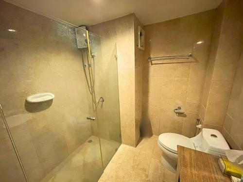 a bathroom with a toilet and a glass shower at Puektian Seaview in Ban Tanot Noi