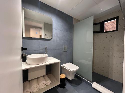 a bathroom with a sink and a toilet at Avra Rooms in Limnionas