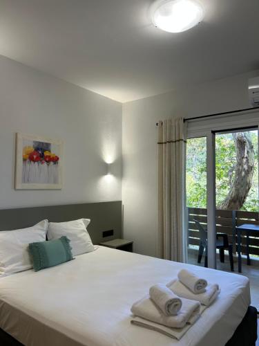 a bedroom with a white bed with towels on it at Avra Rooms in Limnionas