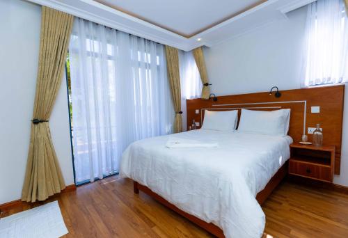 a bedroom with a large bed and a large window at Lusoi Gardens Naromoru in Nyeri
