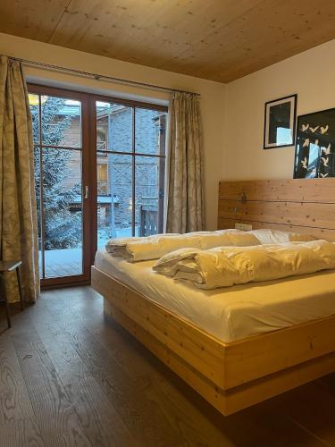 a bedroom with a bed and a large window at Chalet Cosy in Bramberg am Wildkogel
