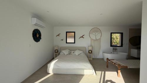 a bedroom with a bed and a tub and a sink at villa la baies des anges in Calcatoggio