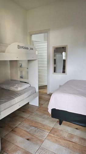 a bedroom with two bunk beds and a mirror at Pousada e SPA Shiva São Sebastião 200mts da praia in São Sebastião