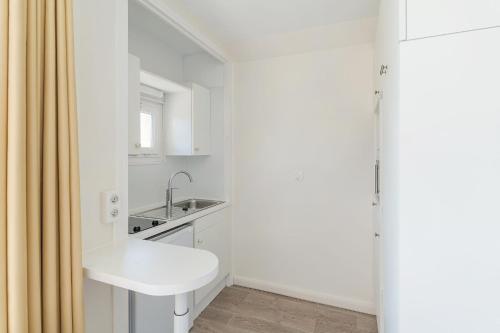 a small white bathroom with a sink and a shower at Résidences LES HAUTES PLAINES in Gréoux-les-Bains
