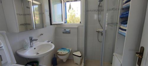 a white bathroom with a sink and a shower at Villa Pilias Methoni in Methoni