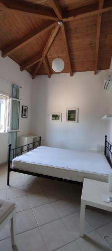 a large bed in a room with a wooden ceiling at Villa Pilias Methoni in Methoni