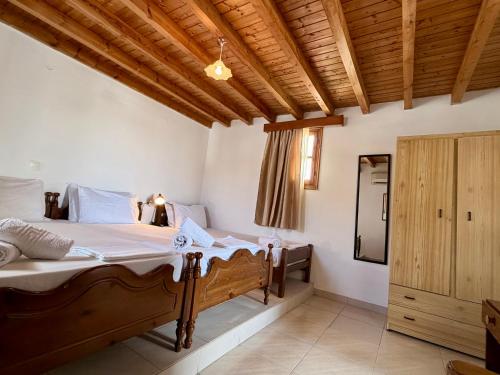 a bedroom with a large bed and a wooden ceiling at Cleopatra's House Apartments in Archangelos