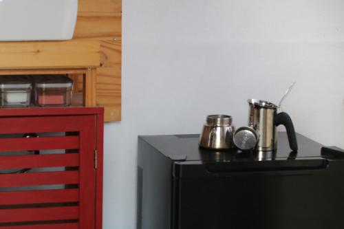 a kitchen with a black refrigerator and a red cabinet at La caravane plage in Pietroso