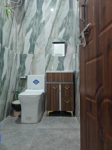 a bathroom with a toilet and a sink at HKS Orchards Stay in Kanatal