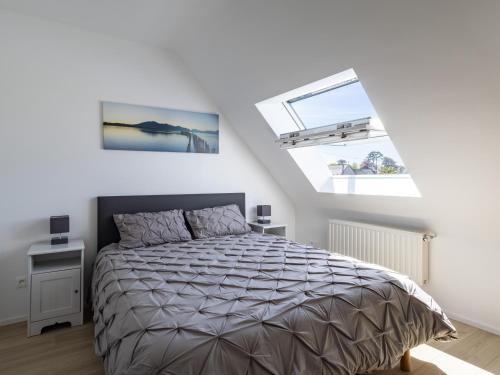 a bedroom with a bed and two windows at Gite Paul Sallou in Perros-Guirec