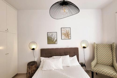 a bedroom with a bed with two lamps and a chair at Mandria Gardens Paradise II in Mandria