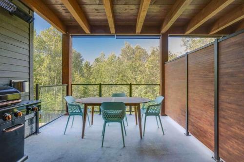 a screened in porch with a table and chairs at Hôtel à la maison - Le Rendez-vous ! in Magog-Orford