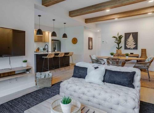 a living room with a couch and a kitchen at Hôtel à la maison - Le Rendez-vous ! in Magog-Orford