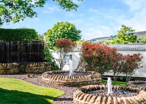 a garden with two fountains in a yard at Heather View Holiday Park in Stanhope
