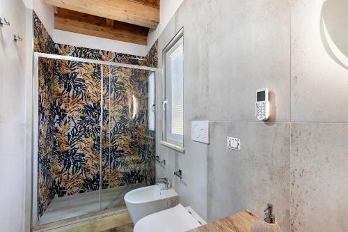 a bathroom with a toilet and a glass shower at Villa Luisana con Piscina e Vista in Sonnino