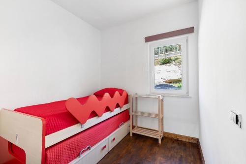 a bedroom with a red bed and a window at Villa Luisana con Piscina e Vista in Sonnino