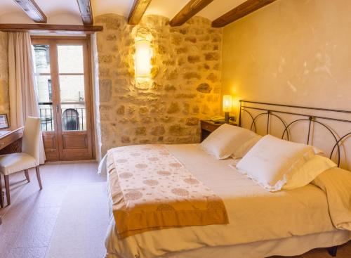 a bedroom with a bed and a desk and a window at Hotel Villa de Cretas in Cretas