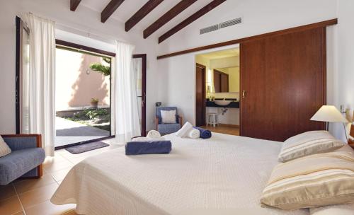 a bedroom with a large bed and a large window at Sa Font den Ros Mallorca in Son Servera