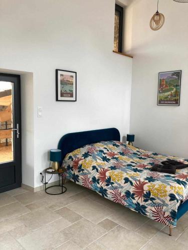 a bedroom with a bed with a colorful comforter at Chez Pauline - Chambres d'hôtes Bourguignonnes in Prissé