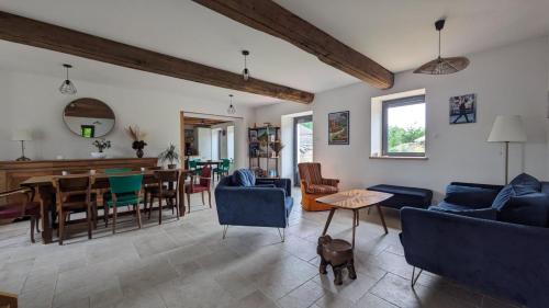 a living room with a blue couch and a table at Chez Pauline - Chambres d'hôtes Bourguignonnes in Prissé