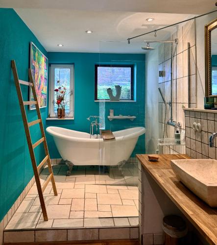 a bathroom with a tub and a blue wall at Haus im Rübental in Bad Dürkheim