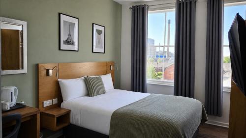 a bedroom with a bed and a large window at Park Hotel & Apartments in Hull