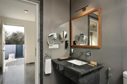 a bathroom with a sink and a mirror at Trulyy The Jawai Leopard Kingdom in Jāmb
