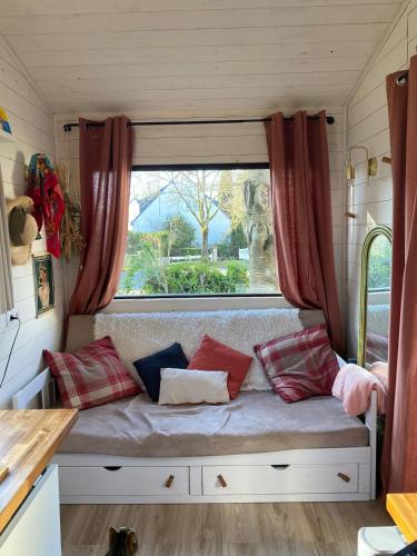 a bench in a tiny caravan with a window at Tiny House de Clara in Avrillé