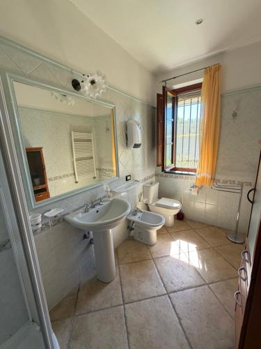 a bathroom with a sink and a toilet and a mirror at Il Chicco d'Oro in Massarosa