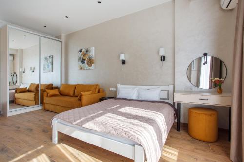 a bedroom with a bed and a mirror and a couch at Five seasons Family in Odesa