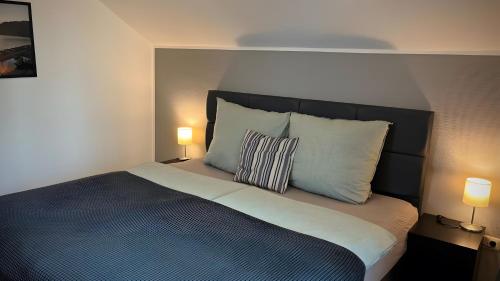 a bedroom with a bed with pillows and two lamps at Maarträumchen in Gillenfeld in Gillenfeld