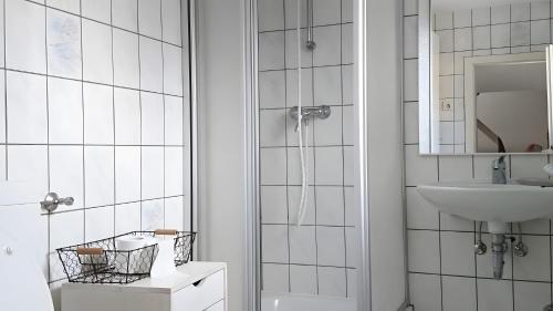 a white bathroom with a sink and a mirror at Gartenhaus in Dodenburg in Dodenburg