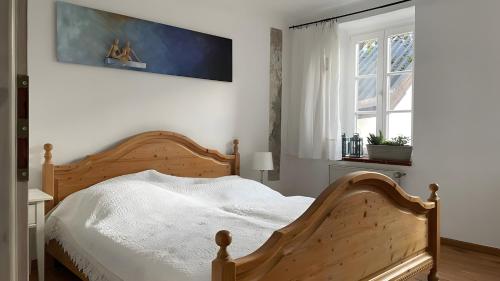 a bedroom with a wooden bed and a window at Gartenhaus in Dodenburg in Dodenburg