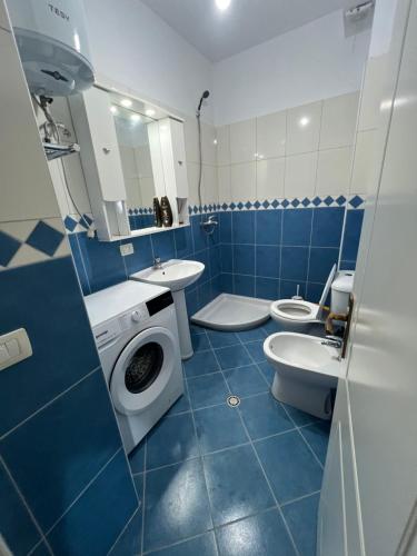a blue and white bathroom with two toilets and a sink at Apartments Kristi in Shëngjin