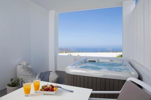 a hot tub in a room with a view of the ocean at Blue Vice Megalochori in Megalochori