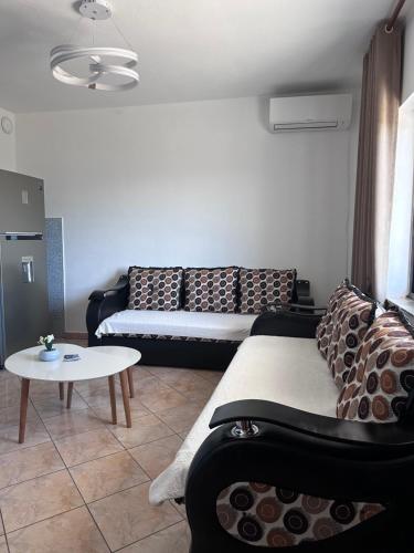 a living room with a couch and a table at Emerald House Shiroke in Shkodër