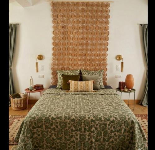a bedroom with a large bed with a large headboard at Chambre d'hôte Maison Magda in Beaucaire