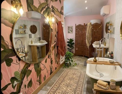 a bathroom with a large mirror and a tub at Chambre d'hôte Maison Magda in Beaucaire