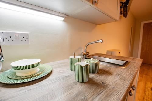 a kitchen counter with three green plates and a sink at Flexistays - Private En-Suite Studios - Kinnegad in Kinnegad