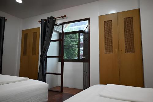 a bedroom with two beds and a window at Patong Beach private Villa in Patong Beach