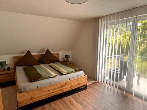 a bedroom with a bed and a large window at Ferienwohnung Hafenblick in Neumagen-Dhron