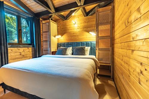 a bedroom with a bed in a wooden cabin at Kuća za odmor Kiara - bazen, jacuzzi i sauna in Karlovac