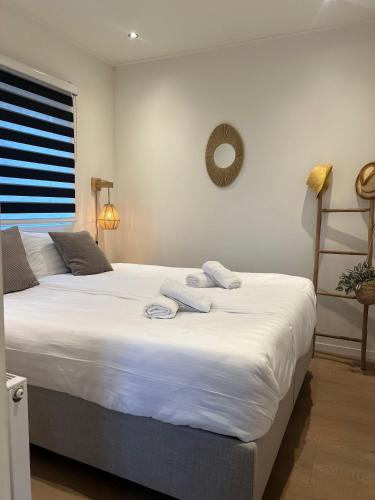 ein Schlafzimmer mit zwei Betten und darauf Handtüchern in der Unterkunft Tiny House Cinta- Dichtbij zee & in een groene omgeving in Heinkensand